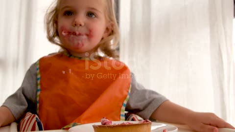 Little girl eating dessert from table فتاة صغيرة تأكل الحلوى من المائدة