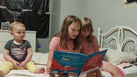 Lily reading a goodnight story to Layla and Josie