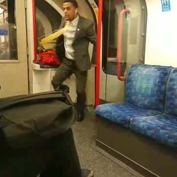 Suit man dances with white headphones in subway