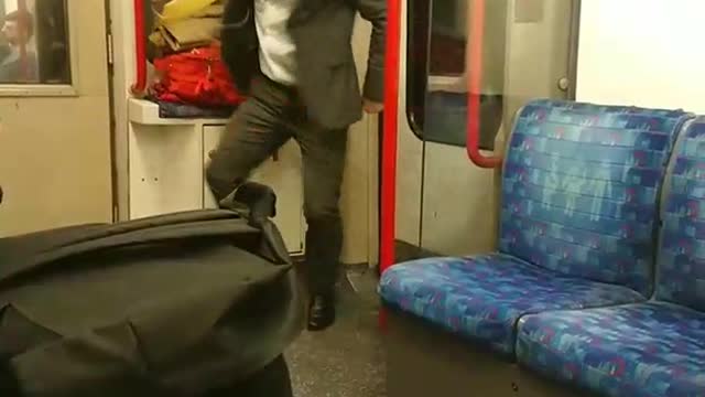 Suit man dances with white headphones in subway