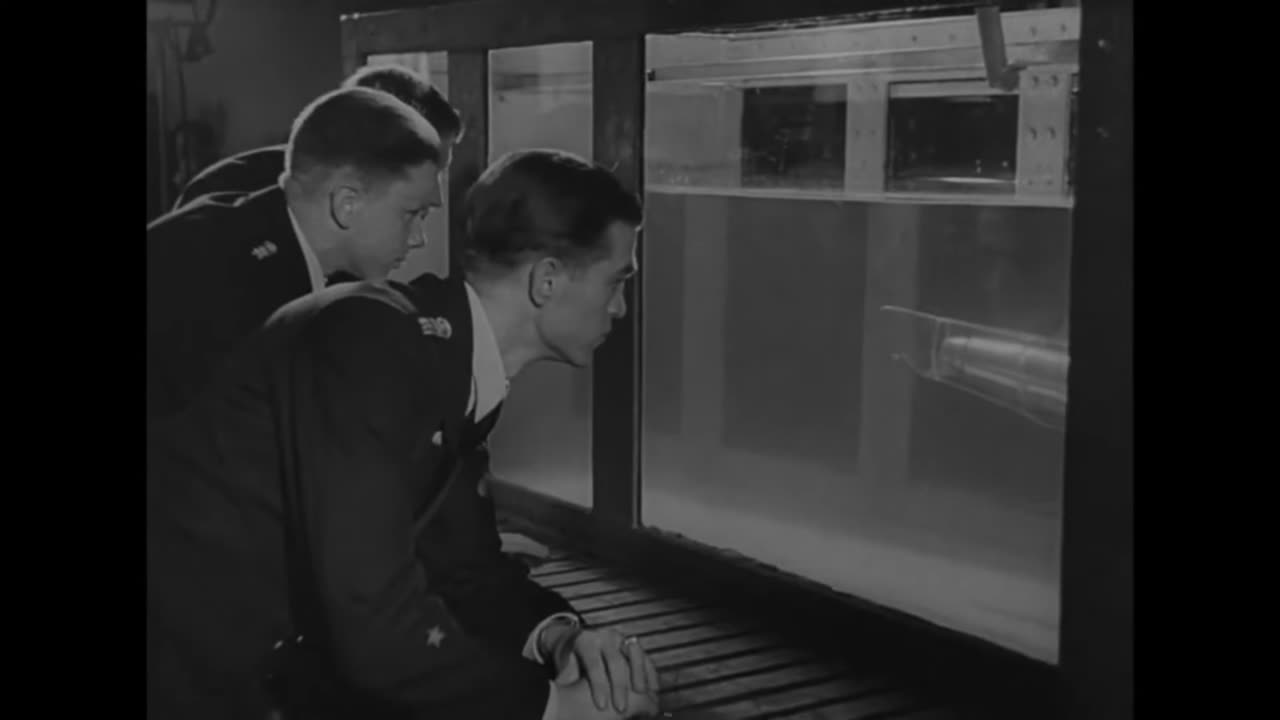 U-Boat trainee crewmen instructed on submarine buoyancy with the use of a transparent model