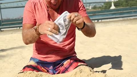 a-man-digging-money-from-the-sand