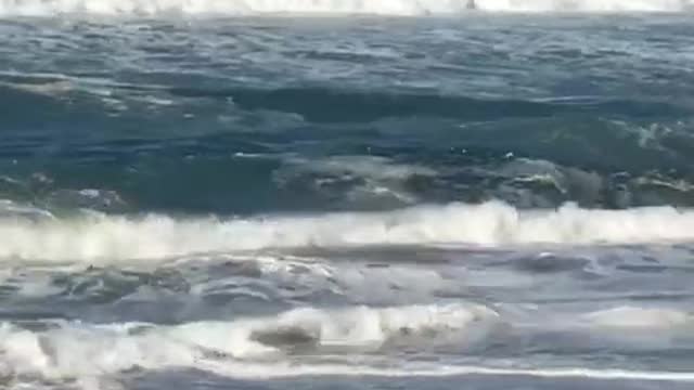 Old shirtless man hit by waves tumbles