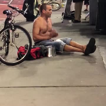 Shirtless guy streets singing drums singing gibberish