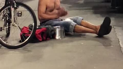 Shirtless guy streets singing drums singing gibberish