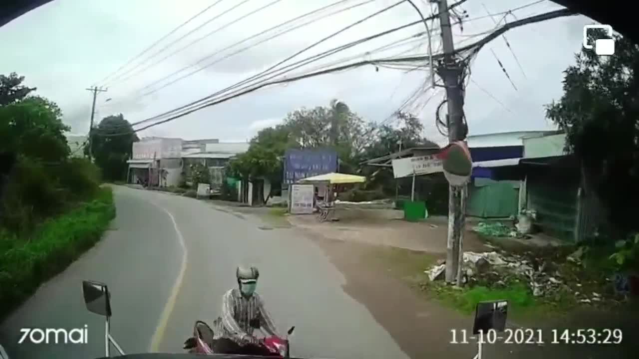 The motorbike in the lane was almost hit by a car