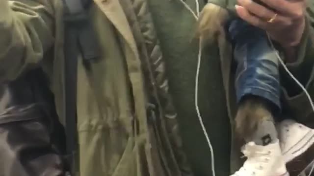 Man holds wolf stuffed animal in green jacket