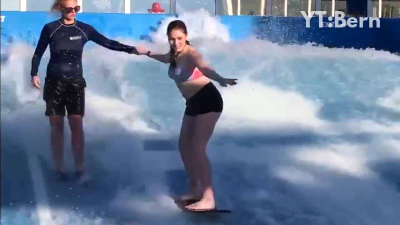 Girl surfing blue wave machine and faceplants