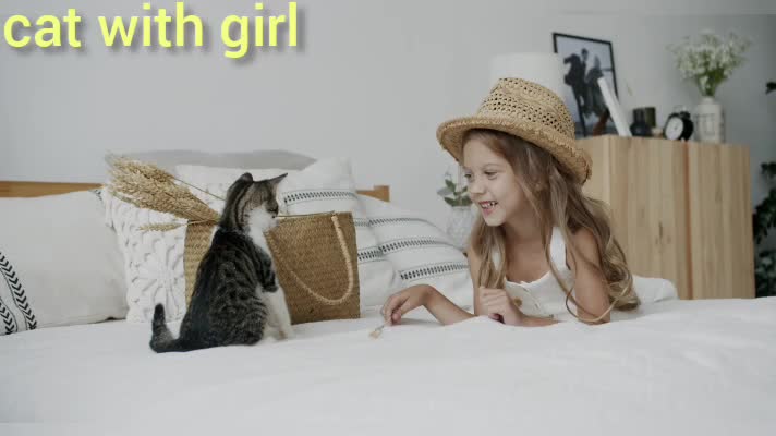 girl playing with her cat in her room on the bed