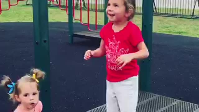 Girl in red shirt misses bars falls on butt