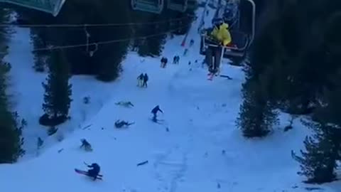 snowboarder loses control of the lift and wipes out everyone behind him.