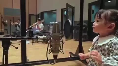 Japanese little girl sings in tune with the musical band