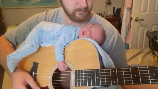 Infant Falls Asleep to Soft Sounds on Dad's Guitar