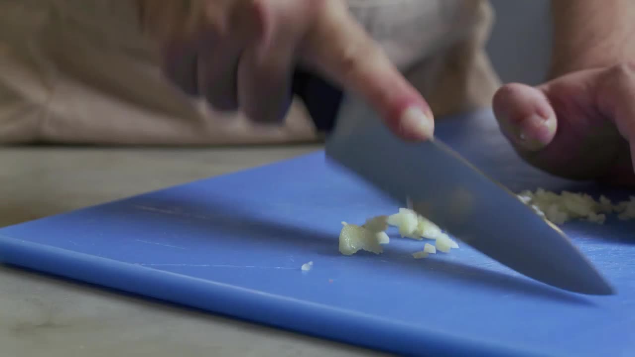 Chef skillfully chopping garlic