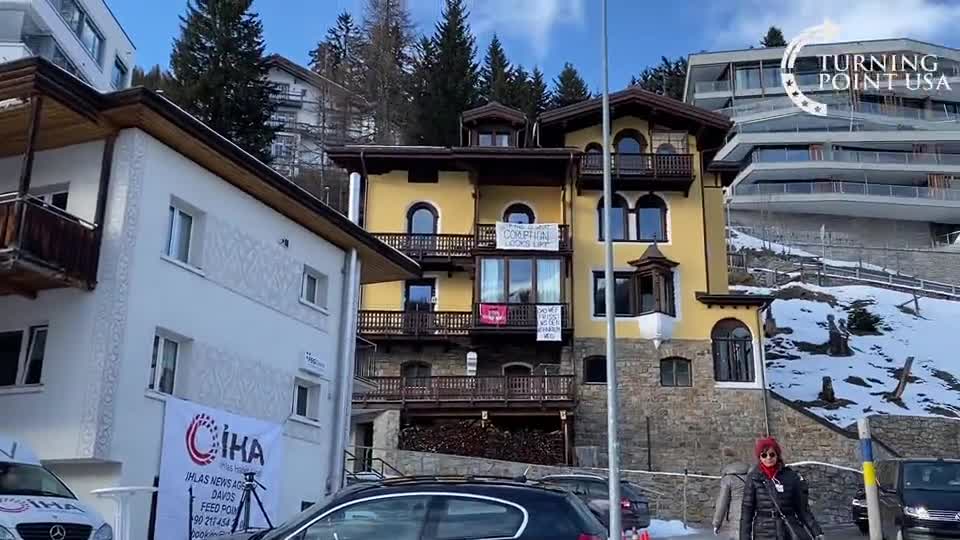 Davos resident with a welcome banner for the WEF reading: ...this is what corruption looks like”!