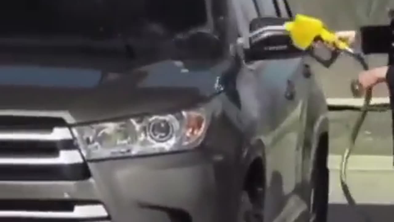 Lady Washes Car at Gas Pump