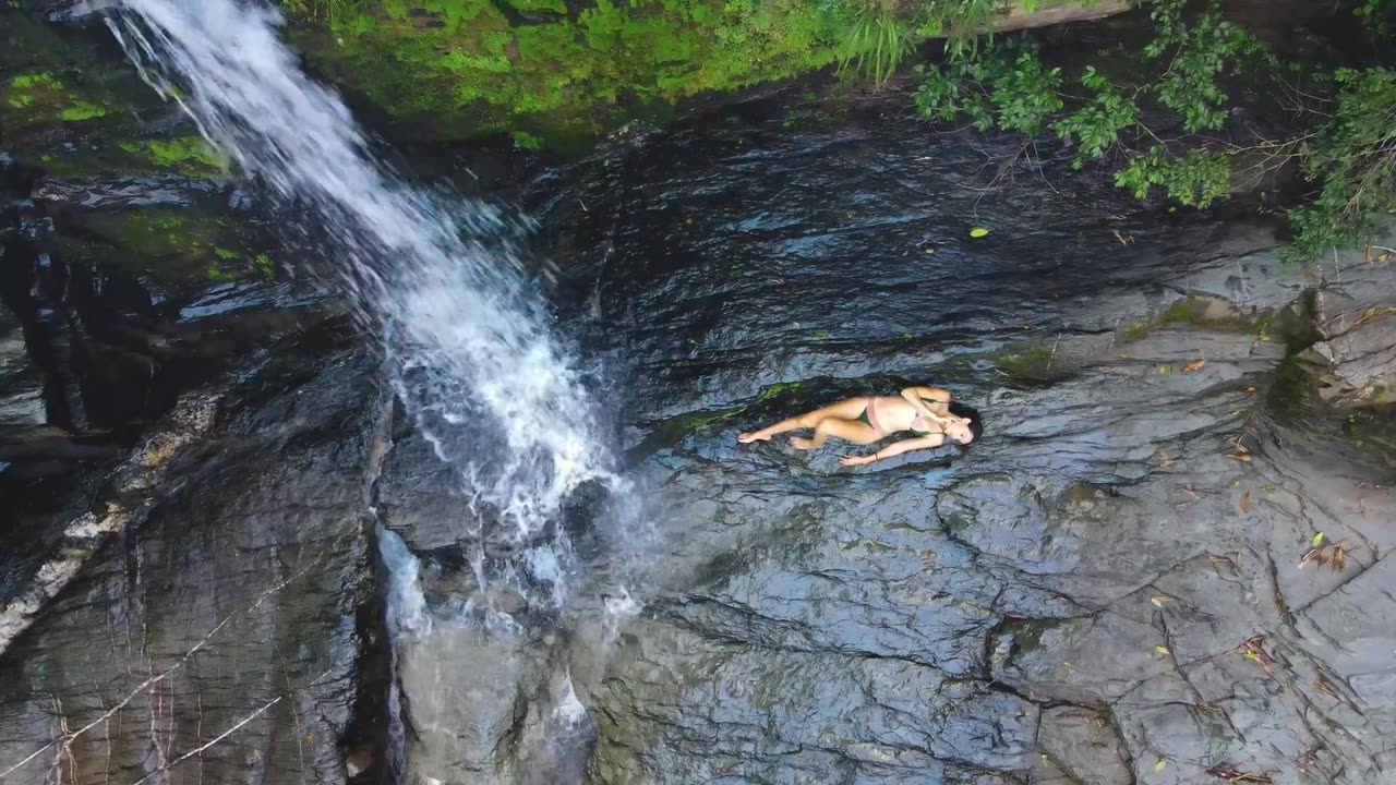 Cute young girl chilling next to a waterfall