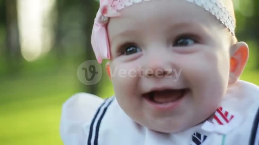 Cute little baby girl sitting on grass.