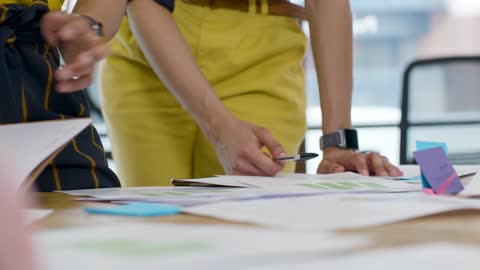 Close Up Of Table With Colleagues Working On Project