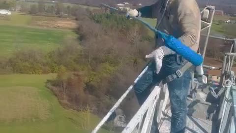 Man Shows How He Paints a Tall Tower for Work