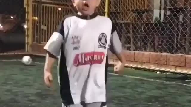 A little boy playing football