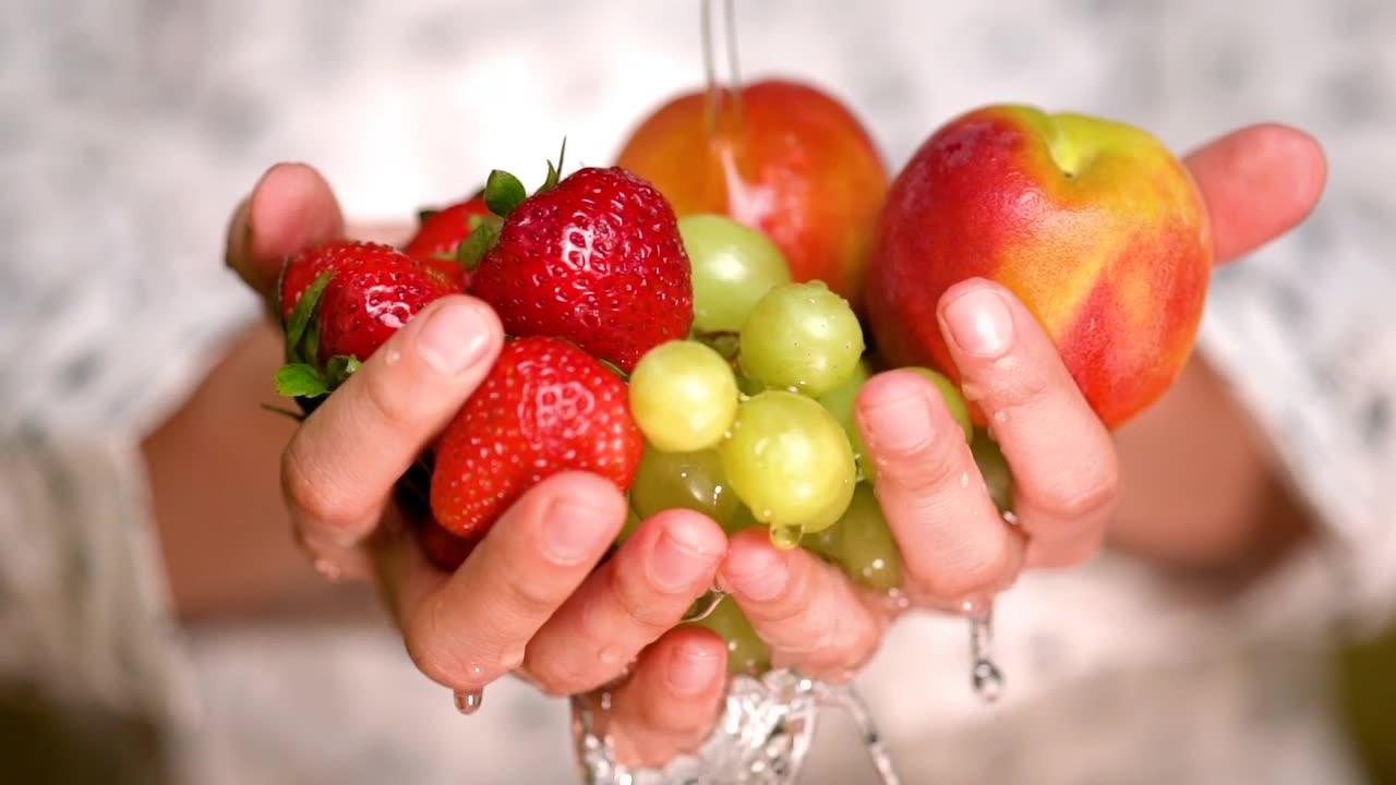Rinsing strawberries, apples and grapes holding hands