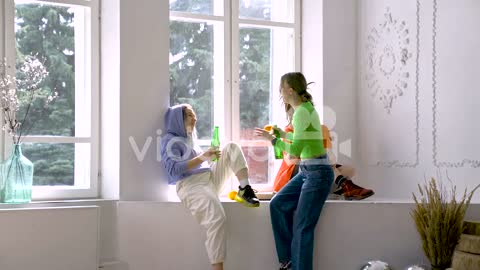 Two Young Friends Eating Fries While Another Friend Comes To Them With An Orange And Toast With Beer