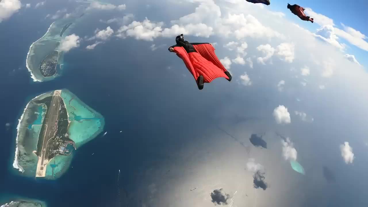 Wing suit flying back over Maldives Island.