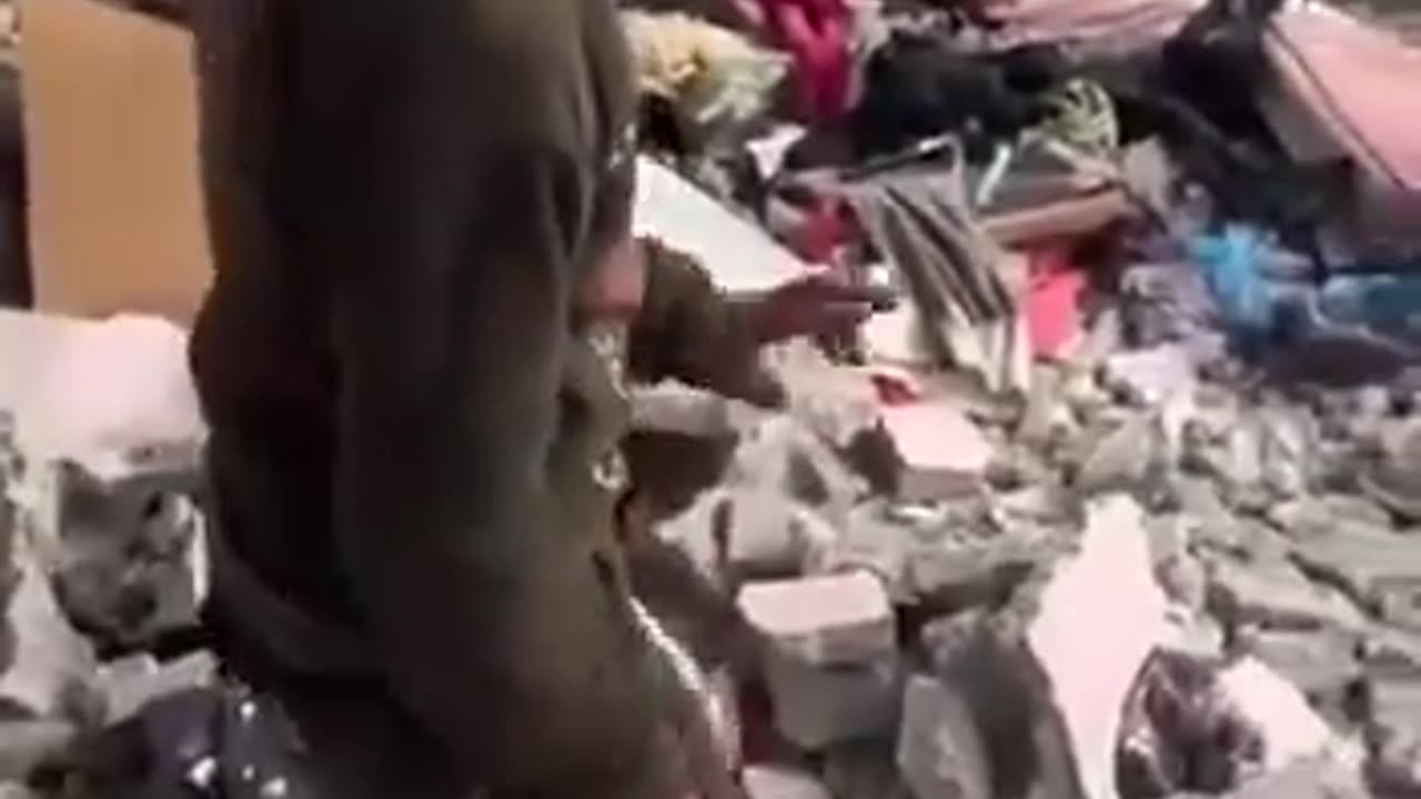 A Palestinian child searches for any remnants of his clothes