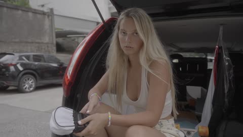 A blonde girl just sitting in the trunk of my car