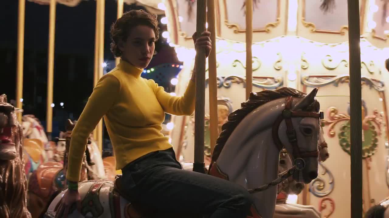 A young woman riding a horse at a carrousel
