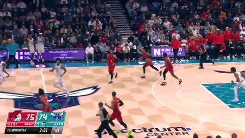 Logo Lillard hits from the Spectrum Center writing in front of the #Hornets bench