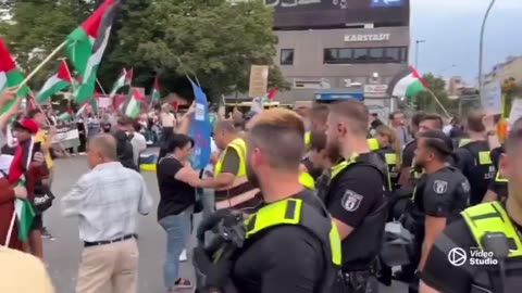 German woman, holding “rape isn’t resistance” sign ,protected by police from anti Israel protesters