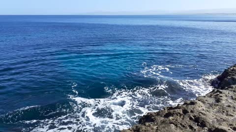 Sea waves crushing on the rocks with white foam