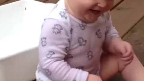 cute baby laughs when splashed with water