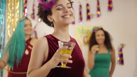 A women dancing while holding a drink