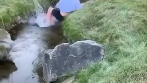 Man walks with speed on a bicycle to cross the other side of the stream