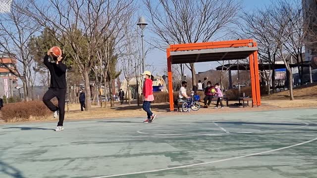 Dad and his daughter playing basketball.