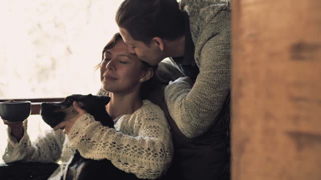 Woman sitting on couch petting dog