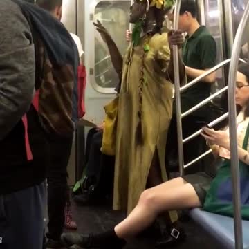 A woman dressed in a yellow dress and large head piece