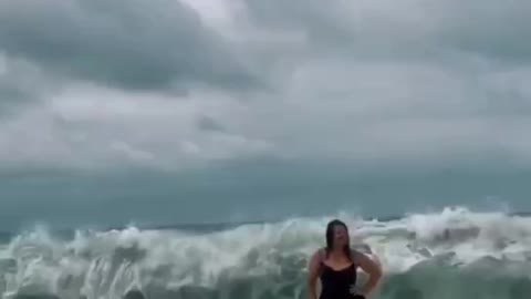 A woman's attempt to take a beautiful photo against the backdrop of the sea