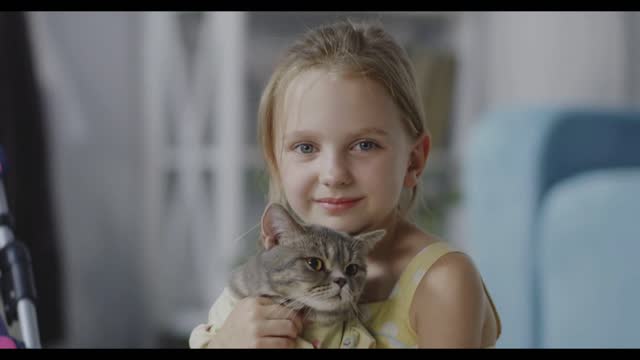 Close up shot of girl holding a cat and looking at camera
