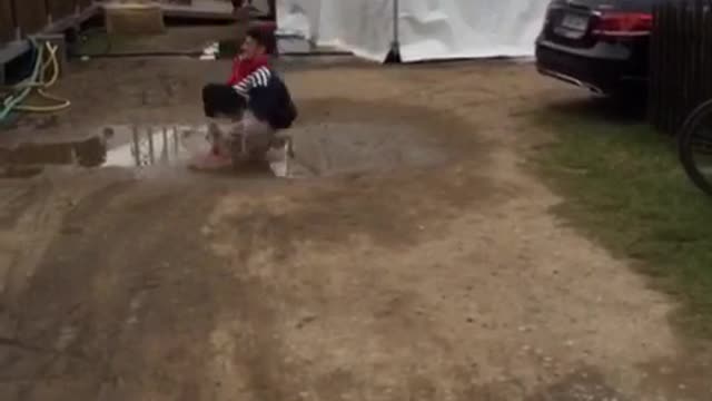 Guy in black clothes and red shoes cannonballs into puddle