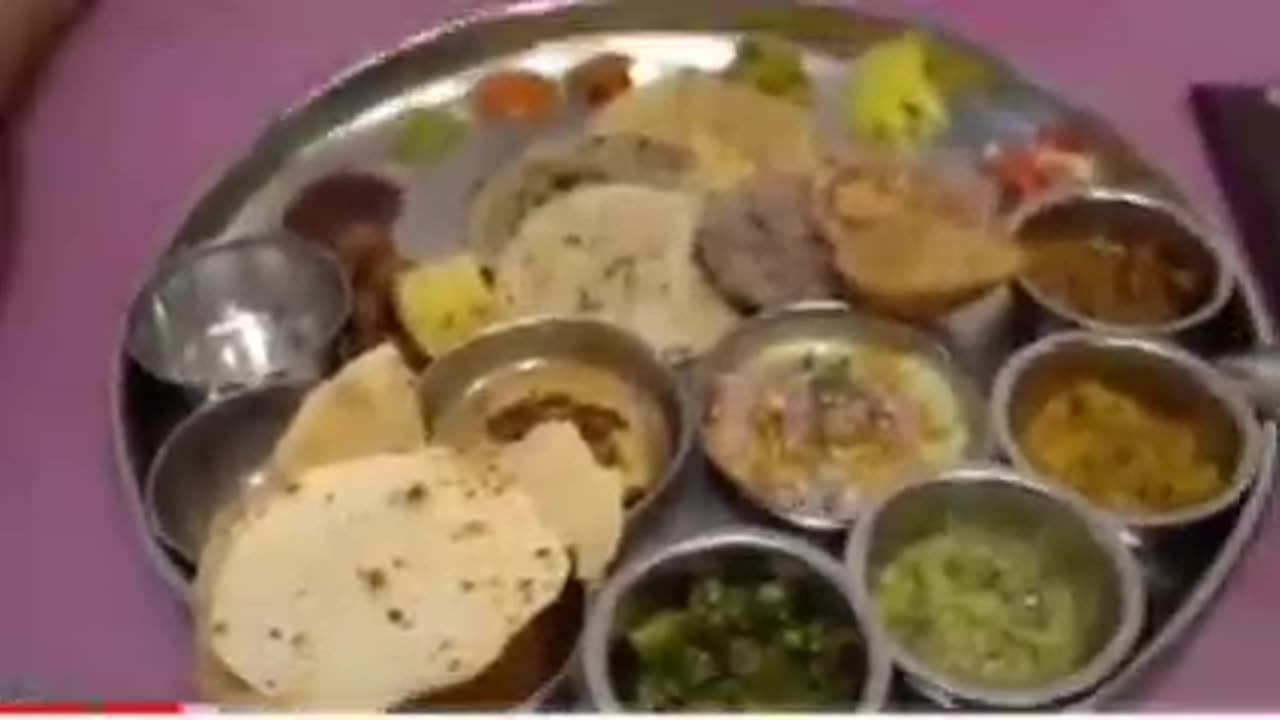 Tasty veg thali has fried okhra dal bhel Puri aam ras cheek pea curry potato curry Puri in it