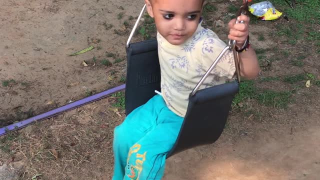 After a long time !! kid is playing on the swing without friends.