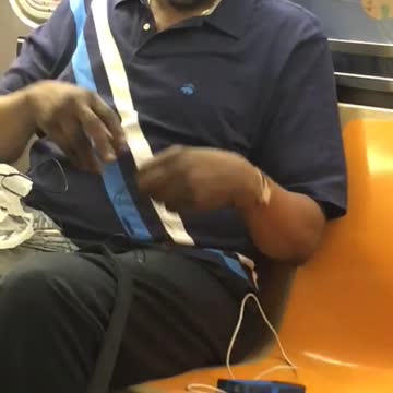 Man with cookie in mouth on subway train