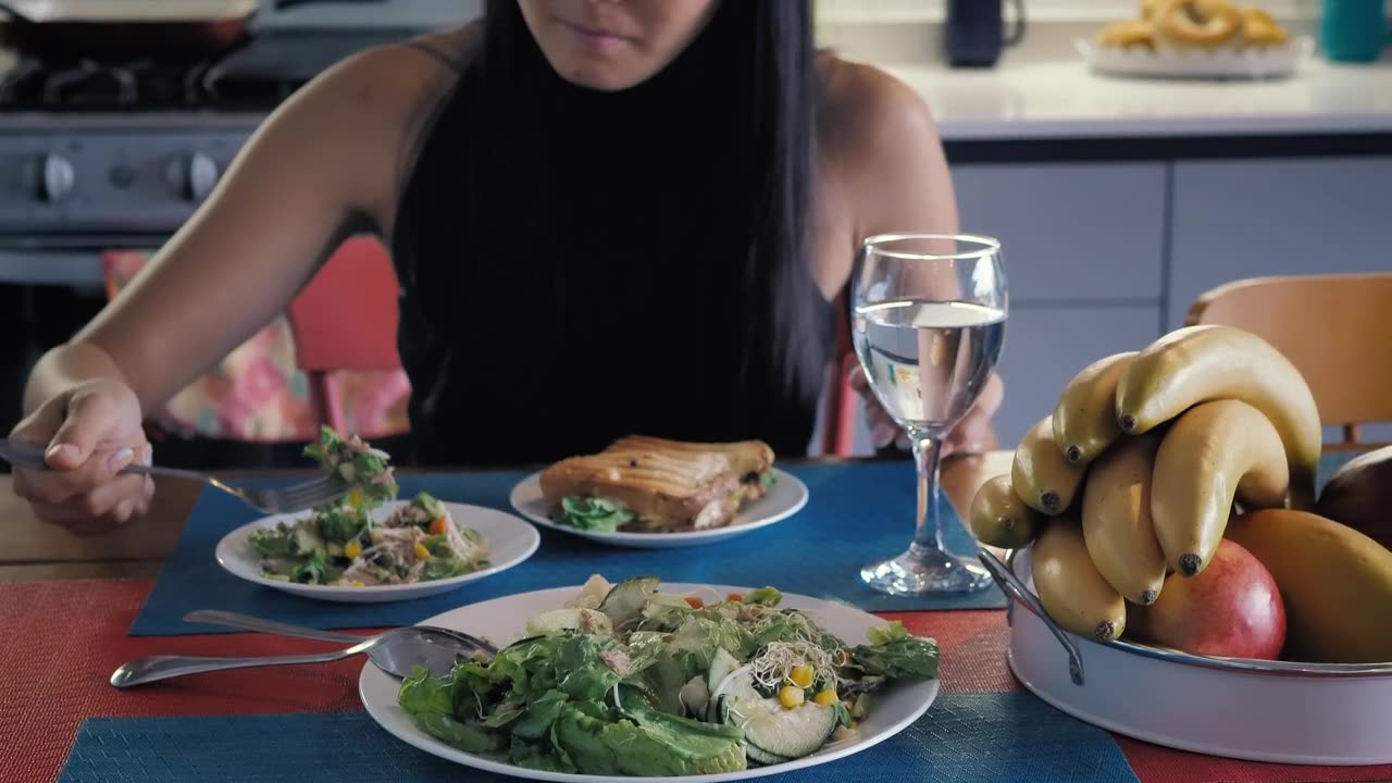 Girl eating salad in her kitchen dining room