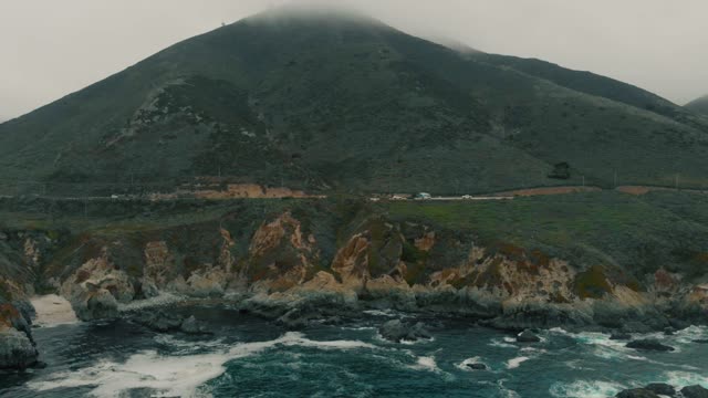 Beautiful Foggy Mountain near beach with a road beside in the morning