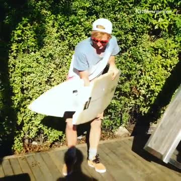 Guy jumps on broken surfboard and slips falls on floor