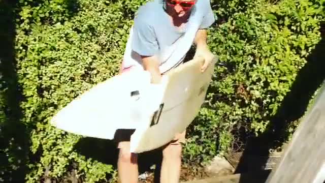 Guy jumps on broken surfboard and slips falls on floor